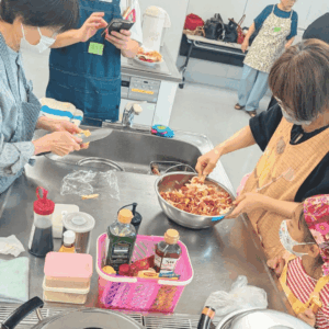 日本人女性２人と、小学生の女の子がサラダを作っている様子