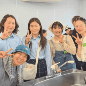 カメラに向かってポーズをとる、日本人女性２人とモンゴル出身の高校生２人と、モンゴル出身の女性１人の様子