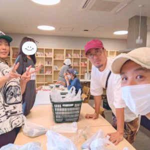 ネオアス村地域食堂で、カメラに向かって笑顔を向けるNeoアスビレッジ代表と事務局長と、ボランティアに来てくださったNPO法人ユニグラウンドの男性スタッフ