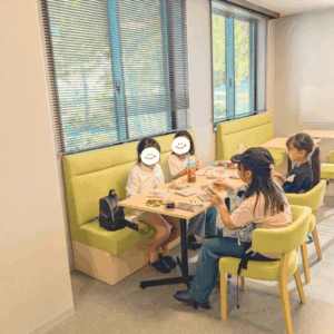 ネオアス村地域食堂で勉強や会話をする小学生の女の子４人の様子