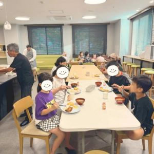 ネオアス村地域食堂で、食事や会話をする子どもたちや、年配の方々の様子
