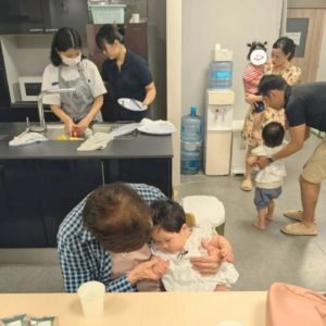 赤ちゃんを抱っこする年配の女性や、子どもをつれて交流をするパパさんママさんたちの様子