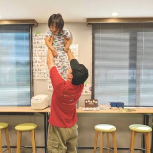 ３歳の子どもさんを高い高いする男性ボランティアの様子