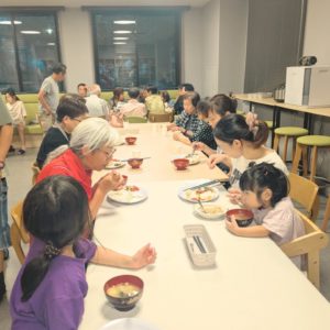 ネオアス村地域食堂で食事や会話をする利用者さんと、学習サポートを行ってくれた敦子先生が一緒に食事をする様子