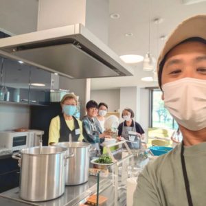 4名の女性ボランティアさんと、Neoアスビレッジの理事長がカメラに向かって笑顔を見せる様子