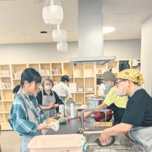 食器洗いや会食の準備をしながらお話をする4名の女性ボランティアさんたちの様子