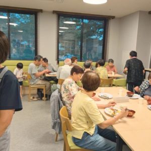 ネオアス村地域食堂で食事や会話を楽しむ利用者さんと子どもたちの様子