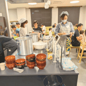 ネオアス村地域食堂で、配膳や盛り付けを行う、ボランティアさんたちの様子