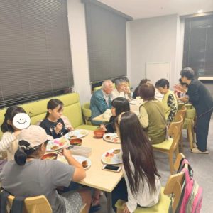 ネオアス村地域食堂で、食事や会話を楽しむ子どもたちや年配の利用者さんたちの様子