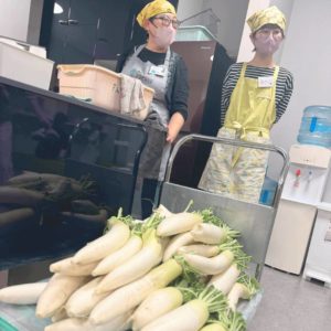 たくさんの大根と、配膳などを行うボランティアさんたちの様子