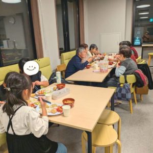 ネオアス村地域食堂で食事や会話を行う様々な年代の利用者さんたちの様子