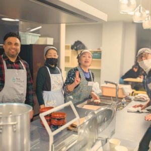 カメラに向かって笑顔を見せる海外出身の男性ボランティア1名と3名の女性ボランティアさんの様子