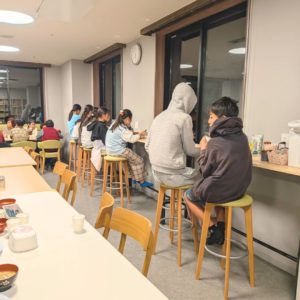 ネオアス村地域食堂のカウンターで食事や会話をする子どもたちの様子