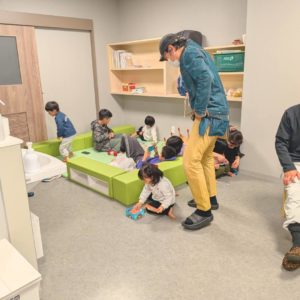 ネオアス村地域食堂のキッズスペースで遊ぶ子どもたちと、それを見守るスタッフの様子