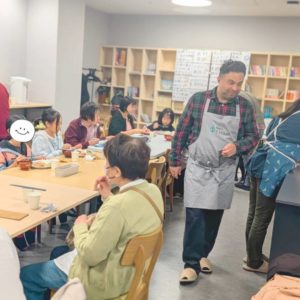 ネオアス村地域食堂で食事や会話を楽しむ利用者さんと配膳などを行うボランティアさんたちの様子