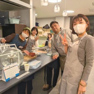 3人の女性ボランティアさんと1人の海外出身の男性ボランティアさんがカメラに向かって笑顔を見せている様子