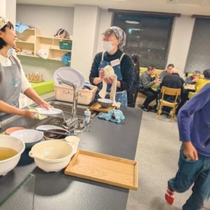 会話をしながらお皿洗いなどをする2人の女性ボランティアの様子