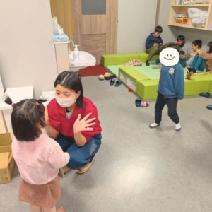 子どもと遊ぶ学生ボランティアさんと、キッズスペースでゲームをする子どもたちの様子