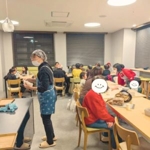 食事や会話を楽しむ利用者さんと食器洗いや配膳などをおこなうボランティアさんたちの様子