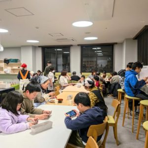 ネオアス村地域食堂で食事や会話を楽しむ様々な年代の利用者さんの様子