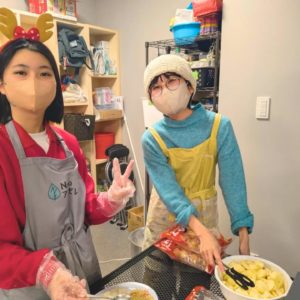 カメラに向かって笑顔を見せる1人の女性学生ボランティアさんと、1名の女性ボランティアさんの様子