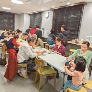 ネオアス村地域食堂で食事や会話をする様々な年代の参加者さんたちの様子