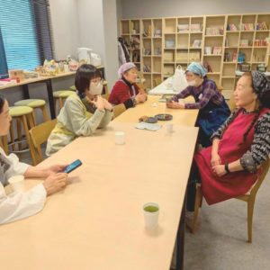 ネオアス村地域食堂のボランティアさんたちが、にこやかに会話やお茶をしながら休憩している様子