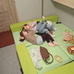 ネオアス村地域食堂のキッズスペースで横になって遊ぶこどもたちの様子