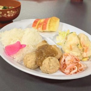 ネオアス村地域食堂で提供された、肉団子や炒め物などがもりつけられているプレート