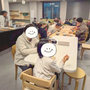 ネオアス村地域食堂で食事や会話を楽しむ様々な年代の参加者さんたちの様子