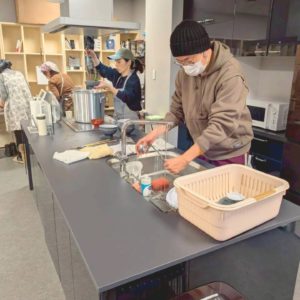 ネオアス村地域食堂で、皿洗いや盛り付けなどを行う、スタッフの様子