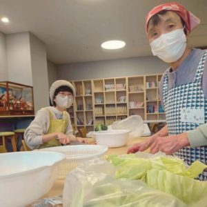 野菜を切っている２名の女性ボランティアの様子